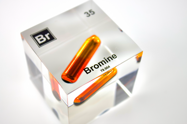 Clear acrylic cube displaying a Bromine element (Atomic Number 35) embedded within, offering a scientific presentation for collectors and science enthusiasts.