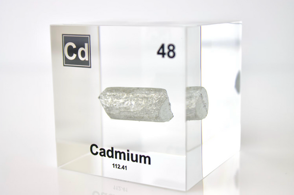 Clear acrylic cube displaying a Cadmium element (Atomic Number 48) embedded within, offering a scientific presentation for collectors and science enthusiasts.