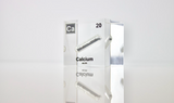 Clear acrylic cube displaying a Calcium element (Atomic Number 20) embedded within, offering a scientific presentation for collectors and science enthusiasts.