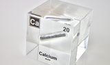 Clear acrylic cube displaying a Calcium element (Atomic Number 20) embedded within, offering a scientific presentation for collectors and science enthusiasts.