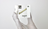 Clear acrylic cube displaying a Cesium element (Atomic Number 55) embedded within, offering a scientific presentation for collectors and science enthusiasts.