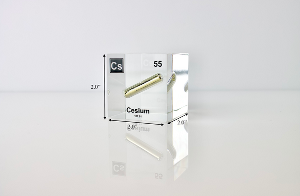 Clear acrylic cube displaying a Cesium element (Atomic Number 55) embedded within, offering a scientific presentation for collectors and science enthusiasts.