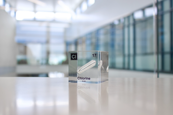 Clear acrylic cube displaying a Chlorine element (Atomic Number 17) embedded within, offering a scientific presentation for collectors and science enthusiasts.