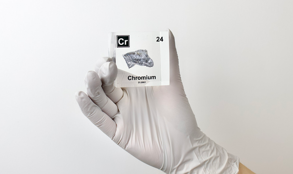 Chromium enclosed in a clear acrylic cube, highlighting its name, atomic number 24, and key properties from the periodic table. A great educational tool and collector’s piece.