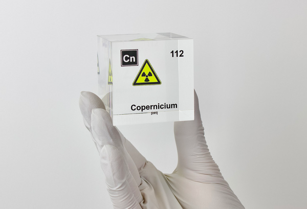 Clear acrylic cube displaying a Copernicium element (Atomic Number 112) embedded within, offering a scientific presentation for collectors and science enthusiasts.