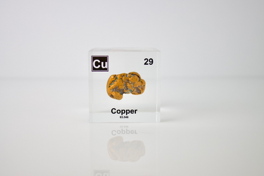 Clear acrylic cube showcasing copper element, including its name, atomic number 29, and properties as featured on the periodic table. Ideal for educational displays and collectors. 