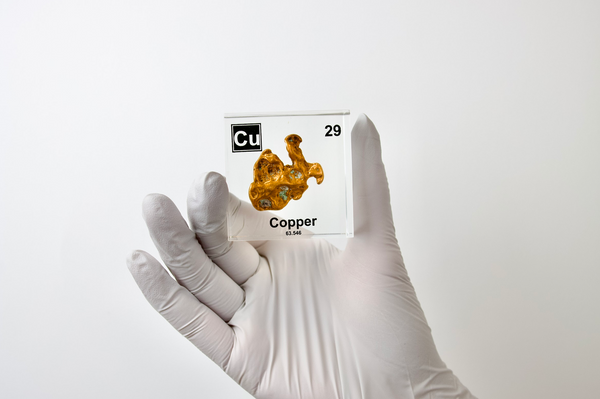 Clear acrylic cube held by hand showcasing copper element, including its name, atomic number 29, and properties as featured on the periodic table. Ideal for educational displays and collectors. 