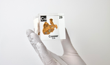 Clear acrylic cube held by hand showcasing copper element, including its name, atomic number 29, and properties as featured on the periodic table. Ideal for educational displays and collectors. 