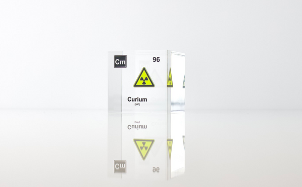 Clear acrylic cube displaying a Curium element (Atomic Number 96) embedded within, offering a scientific presentation for collectors and science enthusiasts.