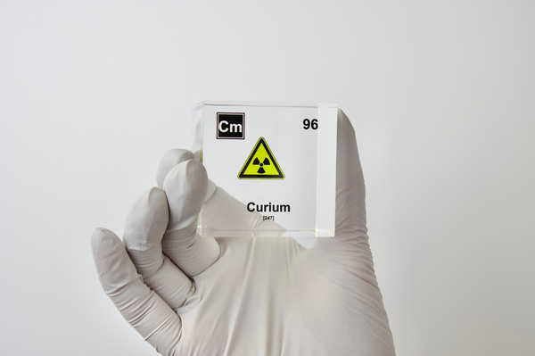 Clear acrylic cube displaying a Curium element (Atomic Number 96) embedded within, offering a scientific presentation for collectors and science enthusiasts.