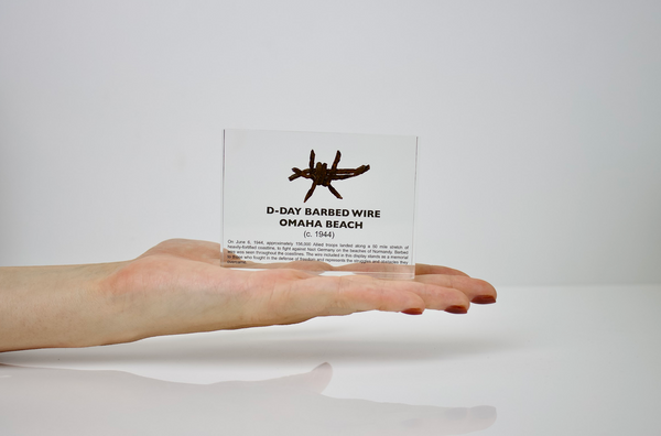 Clear acrylic display case featuring a historical fragment of D-Day barbed wire, offering an educational presentation for collectors and those interested in World War II history.