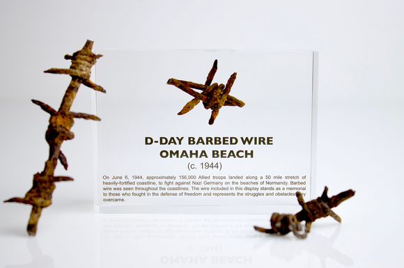 Clear acrylic display case featuring a historical fragment of D-Day barbed wire, offering an educational presentation for collectors and those interested in World War II history.