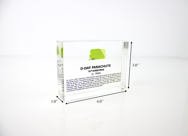 Clear acrylic display case featuring a historical fragment of a D-Day parachute, offering an educational presentation for collectors and those interested in World War II history.