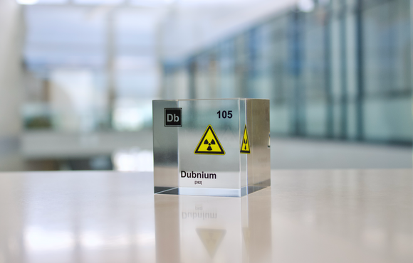 Clear acrylic cube displaying a Dubnium element (Atomic Number 105) embedded within, offering a scientific presentation for collectors and science enthusiasts.