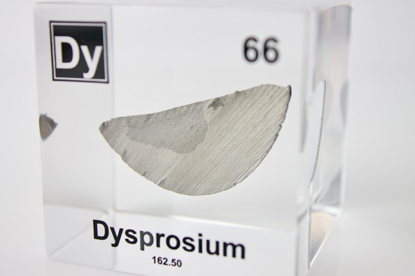 Clear acrylic cube displaying a Dysprosium element (Atomic Number 66) embedded within, offering a scientific presentation for collectors and science enthusiasts.