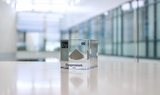 Clear acrylic cube displaying a Dysprosium element (Atomic Number 66) embedded within, offering a scientific presentation for collectors and science enthusiasts.