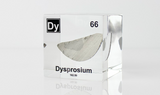 Clear acrylic cube displaying a Dysprosium element (Atomic Number 66) embedded within, offering a scientific presentation for collectors and science enthusiasts.