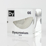 Clear acrylic cube displaying a Dysprosium element (Atomic Number 66) embedded within, offering a scientific presentation for collectors and science enthusiasts.