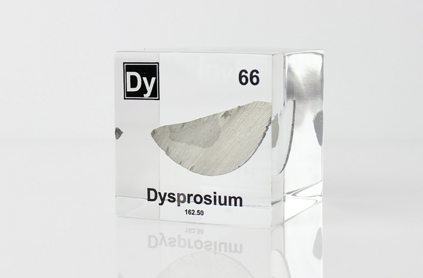 Clear acrylic cube displaying a Dysprosium element (Atomic Number 66) embedded within, offering a scientific presentation for collectors and science enthusiasts.