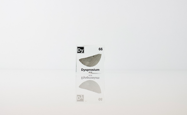 Clear acrylic cube displaying a Dysprosium element (Atomic Number 66) embedded within, offering a scientific presentation for collectors and science enthusiasts.