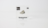 Clear acrylic cube displaying a Dysprosium element (Atomic Number 66) embedded within, offering a scientific presentation for collectors and science enthusiasts.