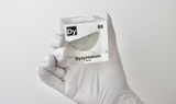 Clear acrylic cube displaying a Dysprosium element (Atomic Number 66) embedded within, offering a scientific presentation for collectors and science enthusiasts.