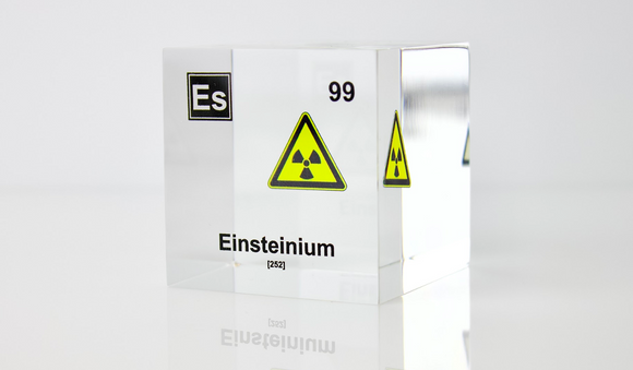 Clear acrylic cube displaying an Einsteinium element (Atomic Number 99) embedded within, offering a scientific presentation for collectors and science enthusiasts.