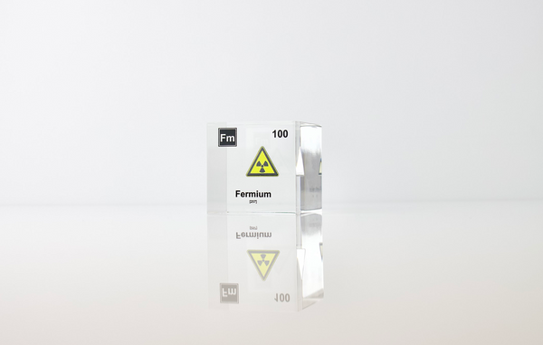 Clear acrylic cube displaying a Fermium element (Atomic Number 100) embedded within, offering a scientific presentation for collectors and science enthusiasts.