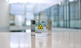 Clear acrylic cube displaying a Fermium element (Atomic Number 100) embedded within, offering a scientific presentation for collectors and science enthusiasts.
