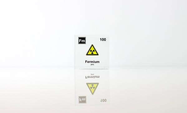 Clear acrylic cube displaying a Fermium element (Atomic Number 100) embedded within, offering a scientific presentation for collectors and science enthusiasts.