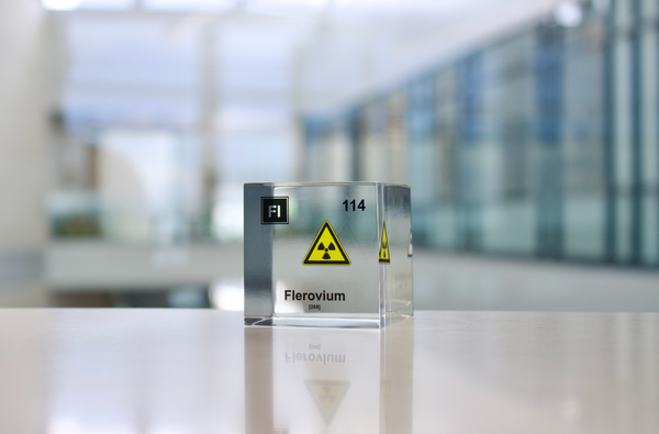 Clear acrylic cube displaying a Flerovium element (Atomic Number 114) embedded within, offering a scientific presentation for collectors and science enthusiasts.