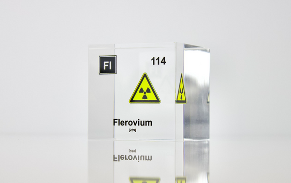 Clear acrylic cube displaying a Flerovium element (Atomic Number 114) embedded within, offering a scientific presentation for collectors and science enthusiasts.