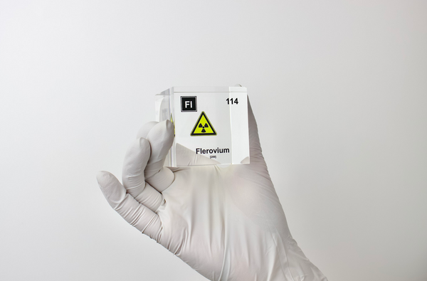 Clear acrylic cube displaying a Flerovium element (Atomic Number 114) embedded within, offering a scientific presentation for collectors and science enthusiasts.