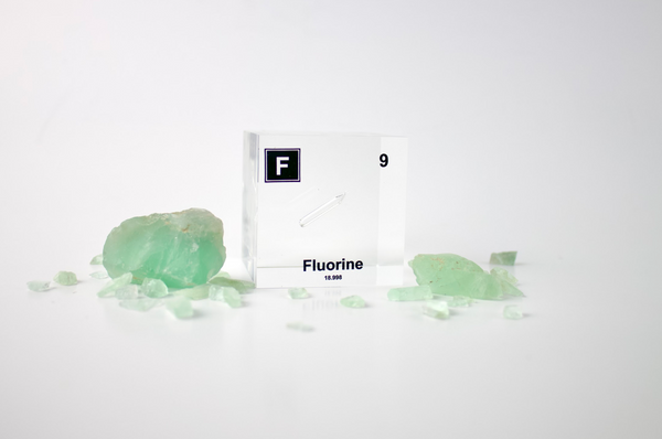 Clear acrylic cube encasing a Fluorine ampule with its atomic number 9. Ideal for display in educational settings, scientific collections, or as a decorative piece.