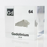 Clear acrylic cube displaying a Gadolinium element (Atomic Number 64) embedded within, offering a scientific presentation for collectors and science enthusiasts.
