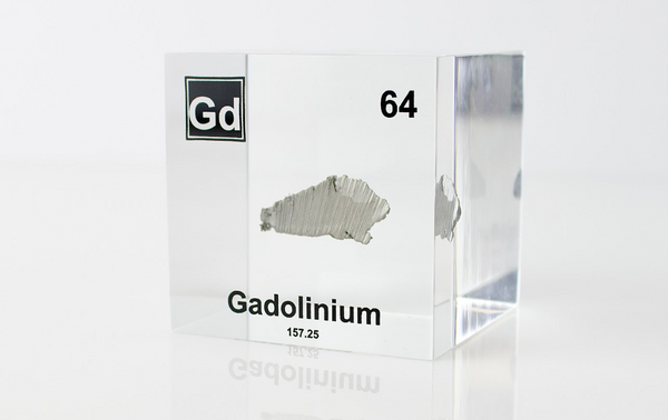 Clear acrylic cube displaying a Gadolinium element (Atomic Number 64) embedded within, offering a scientific presentation for collectors and science enthusiasts.