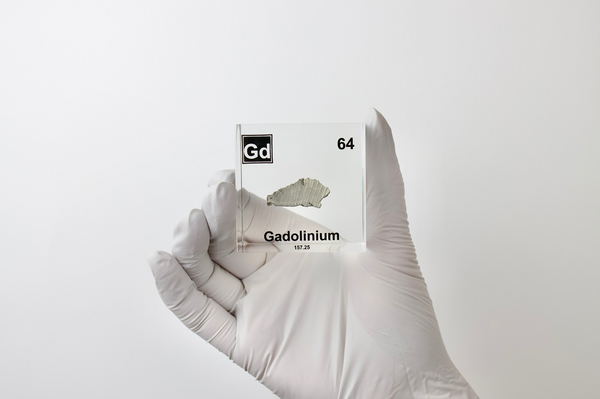 Clear acrylic cube displaying a Gadolinium element (Atomic Number 64) embedded within, offering a scientific presentation for collectors and science enthusiasts.