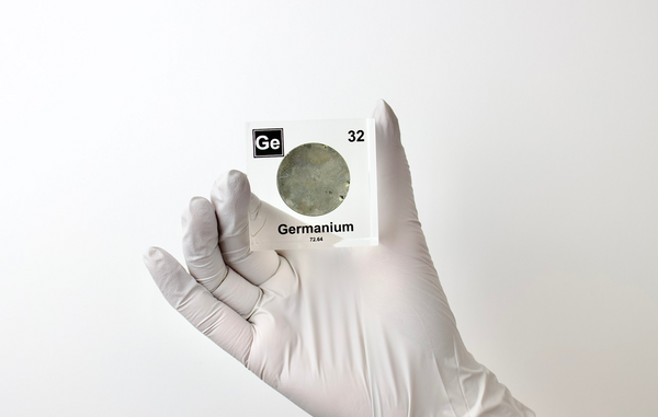 Hand holds a clear acrylic cube displaying Germanium element with its name, atomic number 32, and periodic table properties. Perfect for educational purposes and collectors.