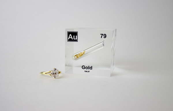 Clear acrylic cube displaying a Gold element (Atomic Number 79) embedded within, offering a scientific presentation for collectors and science enthusiasts.