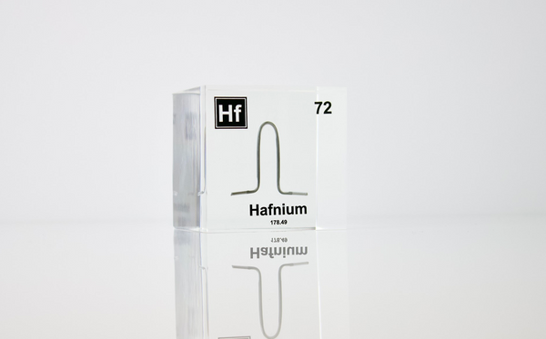 Clear acrylic cube displaying a Hafnium element (Atomic Number 72) embedded within, offering a scientific presentation for collectors and science enthusiasts.