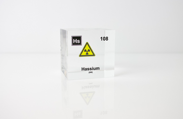 Clear acrylic cube displaying a Hassium element (Atomic Number 108) embedded within, offering a scientific presentation for collectors and science enthusiasts.
