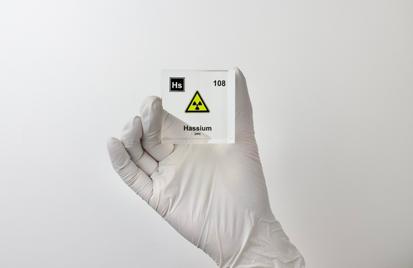 Clear acrylic cube displaying a Hassium element (Atomic Number 108) embedded within, offering a scientific presentation for collectors and science enthusiasts.