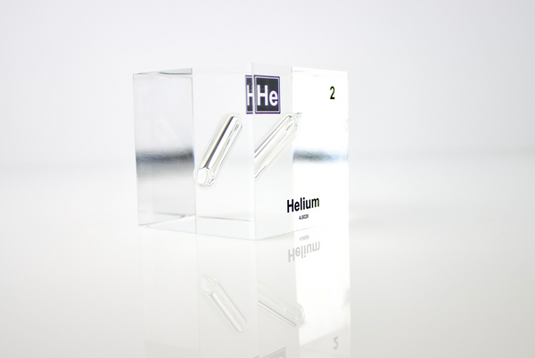 Clear acrylic cube displaying a Helium element (Atomic Number 2) embedded within, offering a scientific presentation for collectors and science enthusiasts.