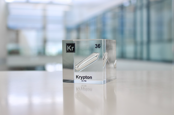 Clear acrylic cube displaying a Krypton element (Atomic Number 36) embedded within, offering a scientific presentation for collectors and science enthusiasts.