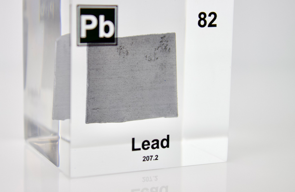 Clear acrylic cube displaying a Lead element (Atomic Number 82) embedded within, offering a scientific presentation for collectors and science enthusiasts.