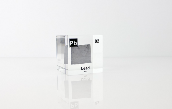 Clear acrylic cube displaying a Lead element (Atomic Number 82) embedded within, offering a scientific presentation for collectors and science enthusiasts.