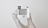 Clear acrylic cube displaying a Lead element (Atomic Number 82) embedded within, offering a scientific presentation for collectors and science enthusiasts.