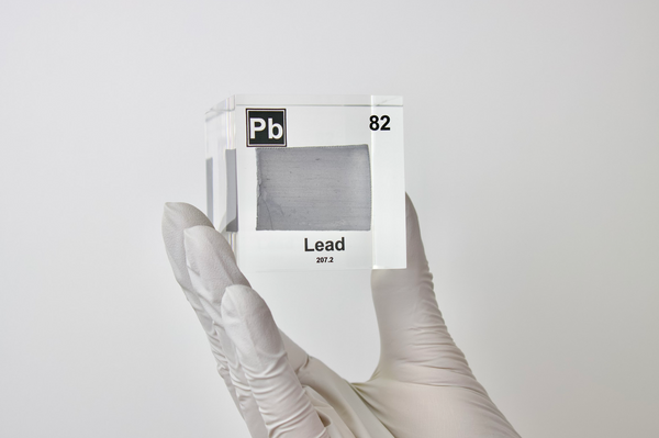 Clear acrylic cube displaying a Lead element (Atomic Number 82) embedded within, offering a scientific presentation for collectors and science enthusiasts.