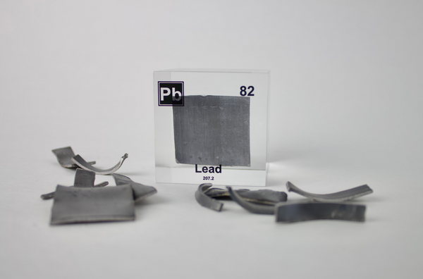 Clear acrylic cube displaying a Lead element (Atomic Number 82) embedded within, offering a scientific presentation for collectors and science enthusiasts.