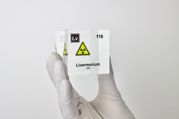 Clear acrylic cube displaying a Livermorium element (Atomic Number 116) embedded within, offering a scientific presentation for collectors and science enthusiasts.